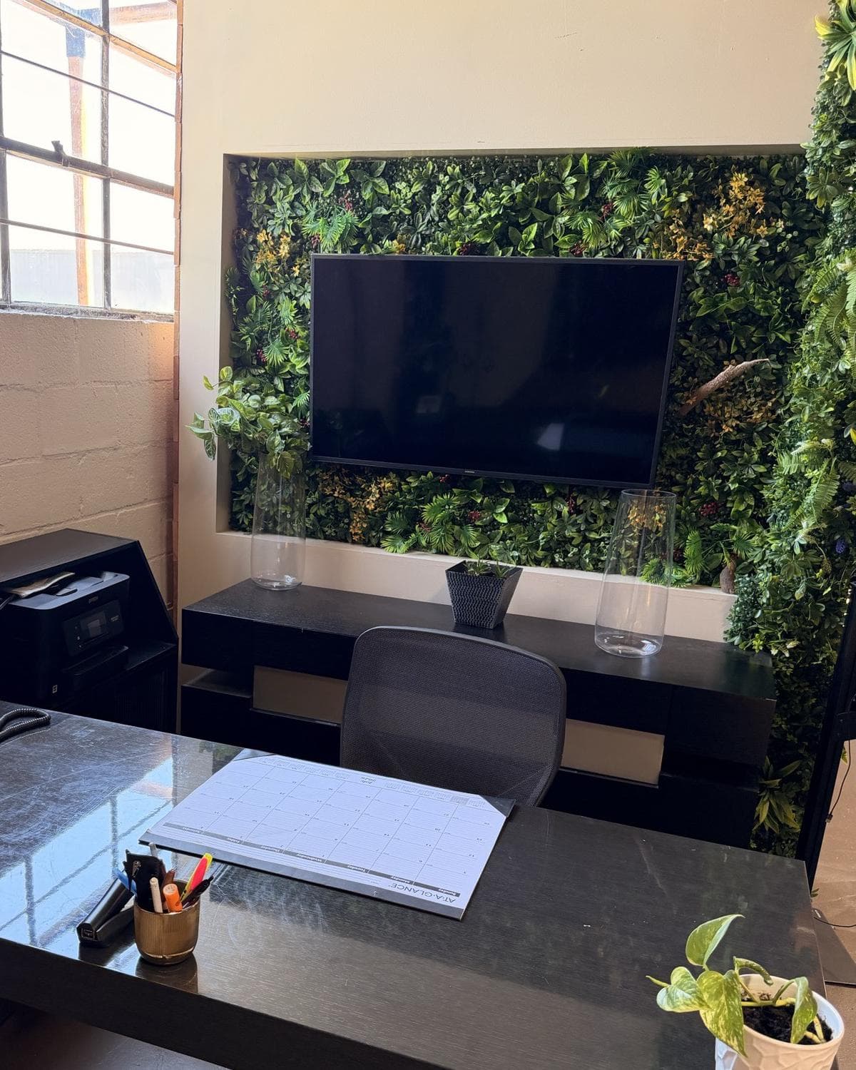 The reception desk set with a live green wall and mounted screen