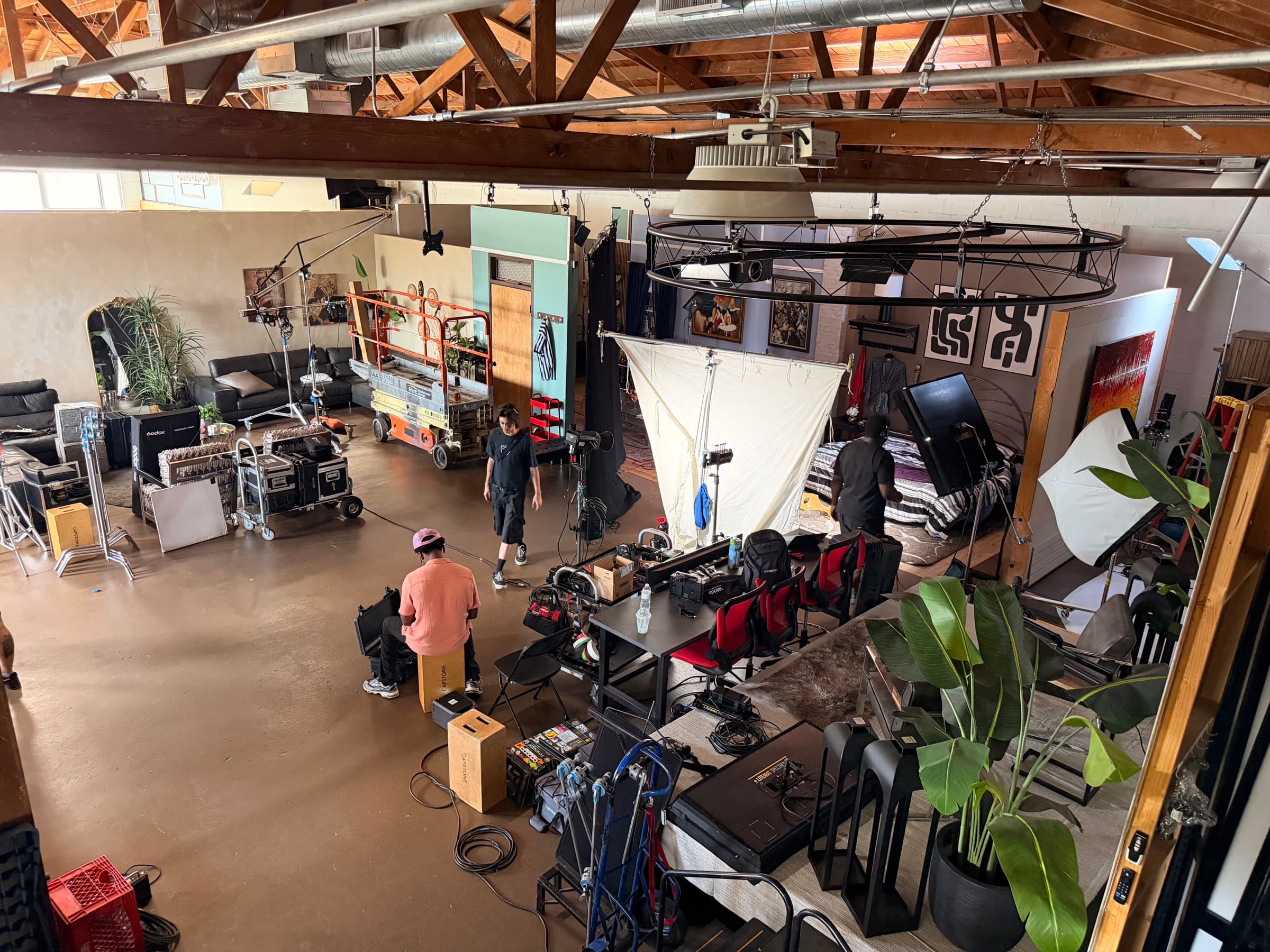 The ACT Immersively floor from above: crew, lighting rig, and standing sets under open timber beams